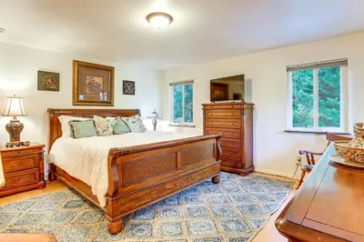 a bedroom with a bed and a dresser and windows at Quiet Home Less Than 1 Mi to Lake Gregory and Dtwn Crestline in Crestline