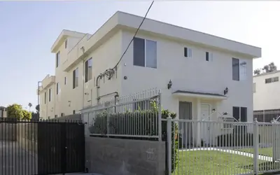 a white house with a fence in front of it at Cozy Bungalow in Hewitt