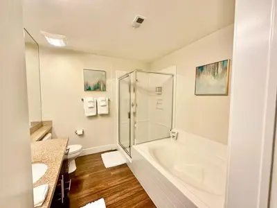 a white bathroom with a tub and a toilet at Spacious 2 BD with 2 King Beds Walk to Pier & Beach in Los Angeles