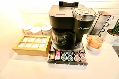 a coffee maker on a counter with a box of donuts at 2 KING BEDS Walk PIER BEACH and 3rd St PROMENADE in Los Angeles
