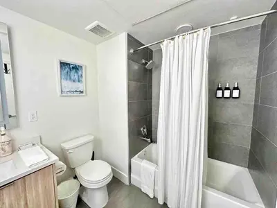 a white bathroom with a toilet and a shower at 2 KING BED SUITE WALK to BEACH,PIER, PROMENADE in Los Angeles