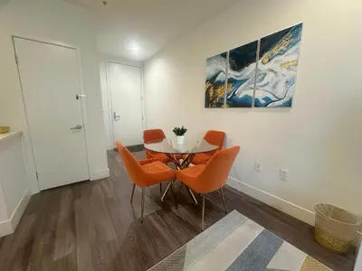 a dining room with a table and orange chairs at 2 KING BED SUITE WALK to BEACH,PIER, PROMENADE in Los Angeles