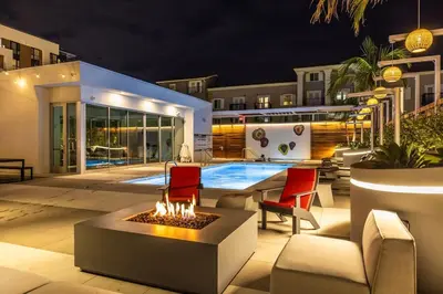 a backyard with a fire pit and a pool at night at Marbella Lane - Sleek Corner Ocean View in Long Beach