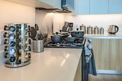 a kitchen with a stove with pots and pans at Marbella Lane - Sleek Corner Ocean View in Long Beach