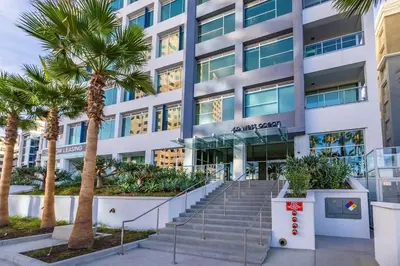 a building with palm trees in front of it at Marbella Lane - Sleek Corner Ocean View in Long Beach