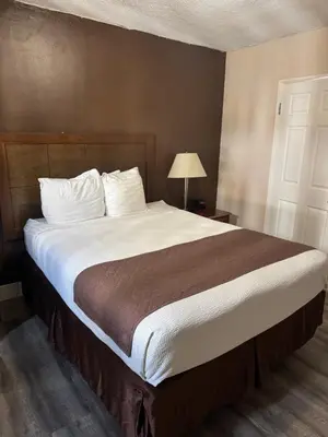 a bedroom with a large bed with white pillows at Holiday Lodge in Los Angeles