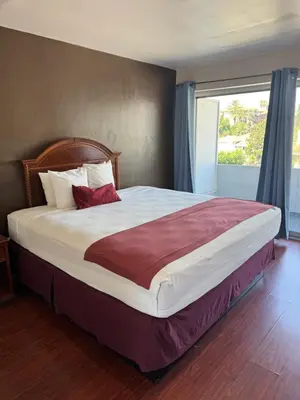 a large bed in a bedroom with a large window at Holiday Lodge in Los Angeles