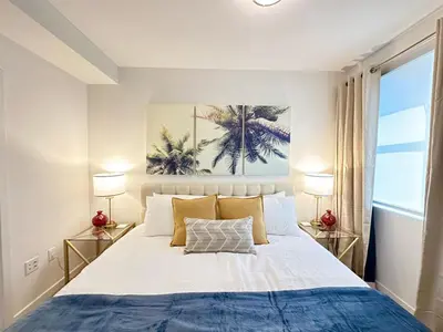 a bedroom with a large bed with two lamps at 5 Star Location with City Views 2BD 2BA with King Beds in Los Angeles