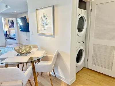 a living room with a table and a washing machine at 5 Star Location with City Views 2BD 2BA with King Beds in Los Angeles