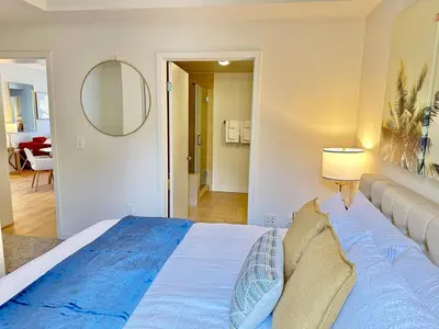 a bedroom with a large bed and a mirror at 5 Star Location with City Views 2BD 2BA with King Beds in Los Angeles