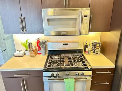 a kitchen with a stove and a microwave at 5 Star Location with Open City Views 2BD 2BA with King Beds in Los Angeles