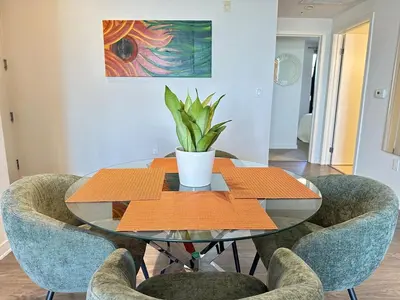 a glass table with chairs and a potted plant on it at 5 Star Location with Open City Views 2BD 2BA with King Beds in Los Angeles