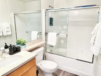 a bathroom with a toilet and a glass shower at Bright 2 Bed 2 Bath with Views Walk to the Beach DTSM in Los Angeles
