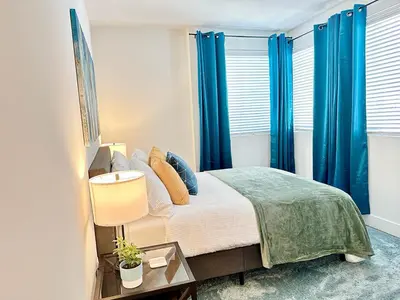 a bedroom with a bed with blue curtains at Bright 2 Bed 2 Bath with Views Walk to the Beach DTSM in Los Angeles