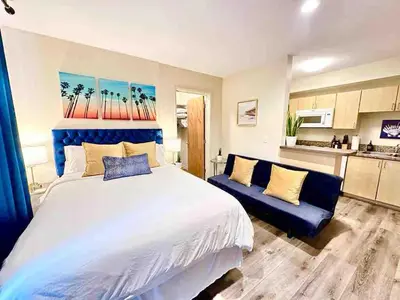 a bedroom with a large bed and a blue couch at Heart of DT SM Studio, Walk To Beach & Pier in Los Angeles