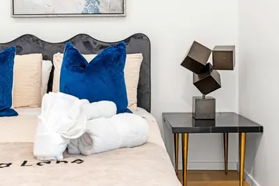 a bedroom with a bed with blue pillows at Marbella Lane - Panoramic Splendid Ocean Views in Long Beach