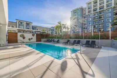 a swimming pool with chairs and a building at Marbella Lane - Panoramic Splendid Ocean Views in Long Beach