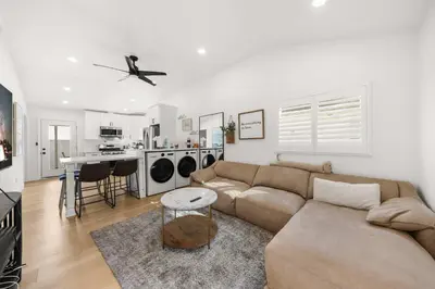 a living room with a brown couch and a kitchen at Marbella Lane - Cityside Haven w Touch of Charm in Compton