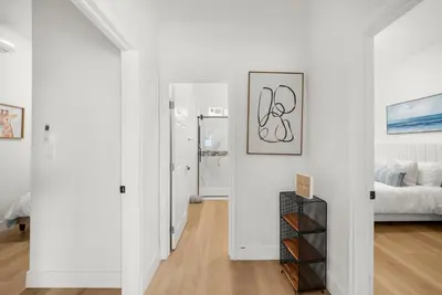 a white apartment with white walls and wood floors at Marbella Lane - Cityside Haven w Touch of Charm in Compton