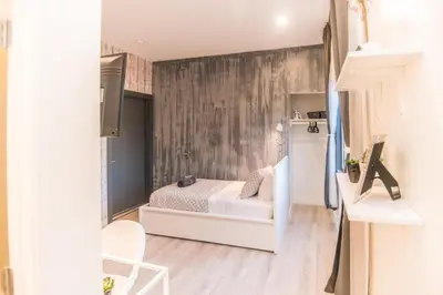 a small bedroom with a bed and a wall at Cozy Private Studio, Private Entry in USC DPS Zone - DQA6 in Los Angeles