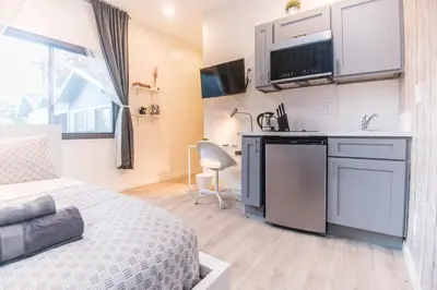 a bedroom with a bed and a kitchen with a sink at Cozy Private Studio, Private Entry in USC DPS Zone - DQA6 in Los Angeles