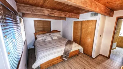 a bedroom with a large bed in a house at Cozy Cabin Retreat with a Hot Tub in Running Springs