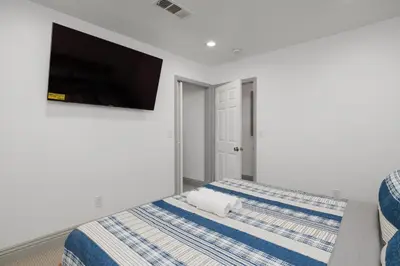 a bedroom with two beds and a flat screen tv at Cozy Private 1BR Near LAX & SoFi, Pet-Friendly in Los Angeles