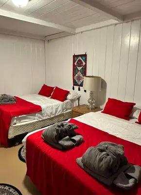 two beds in a room with red and white at Naryn Guest House 3 in Los Angeles