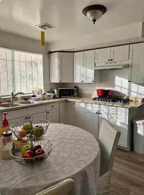 a kitchen with a table with a bowl of fruit on it at Naryn Guest House 3 in Los Angeles