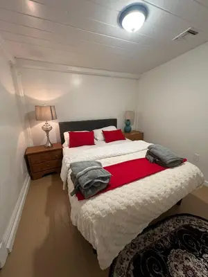 a bedroom with a large bed with red pillows at Naryn Guest House 3 in Los Angeles
