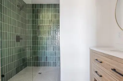a bathroom with a shower with green tiles at Blueground East Hollywood rooftop nr Griffith Park LAX-1335 in Los Angeles