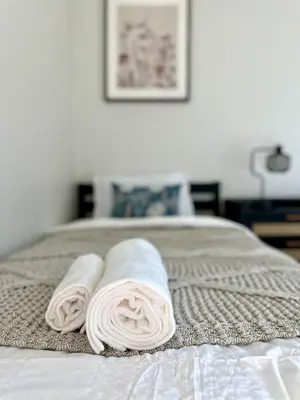 two towels are rolled up on a bed at The Mills Retreat in Whittier Near Disney in Whittier
