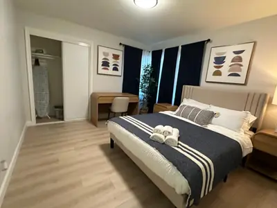 a bedroom with a large bed with blue curtains at The Mills Retreat in Whittier Near Disney in Whittier