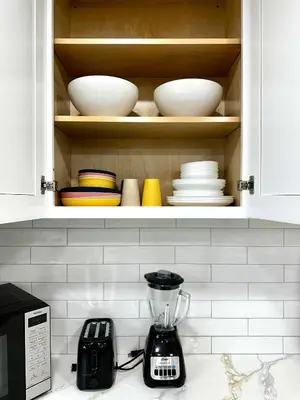 a cupboard with plates and bowls and a blender on a counter at The Mills Retreat in Whittier Near Disney in Whittier