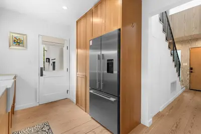 a kitchen with a stainless steel refrigerator in a hallway at New Listing Venice Villa by Colby & Conrad in Los Angeles