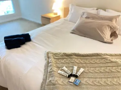 a white bed with a black bow tie on it at Cozy stay by Anatolian in Los Angeles