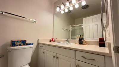 a bathroom with a toilet and a sink and a mirror at Cozy stay by Anatolian in Los Angeles