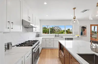 a kitchen with white cabinets and a stove top oven at Ocean View Luxury 5BR Modern Coastal Home in Rancho Palos Verdes