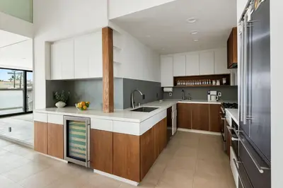 a large kitchen with wooden cabinets and a sink at Northstar Premium Ocean Penthouse in Los Angeles