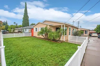 a house with a white fence and a yard at Welcome to your home at the Orange Circle in Orange