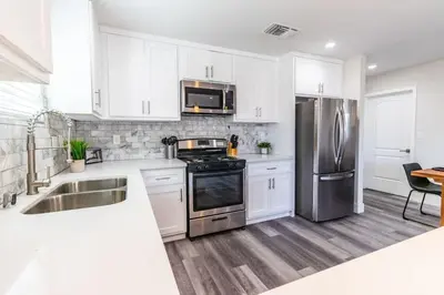 a kitchen with white cabinets and stainless steel appliances at Escape in Modern 4BR Home Sleeps 10 with Parking in Burbank