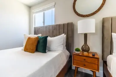 a bedroom with a bed and a table with a lamp at Escape in Modern 4BR Home Sleeps 10 with Parking in Burbank