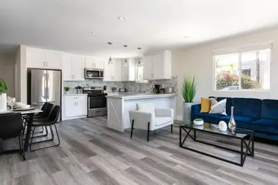 a living room with a blue couch and a kitchen at Spacious Home Central Area Airport Free Parking in Burbank