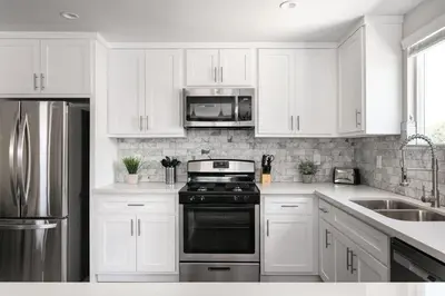 a kitchen with white cabinets and a stove top oven at Spacious Home Central Area Airport Free Parking in Burbank