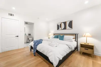 a bedroom with a large bed with white sheets and blue pillows at Charming LA Gem by SOFI, Games & Close to it ALL in Los Angeles