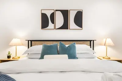 a bedroom with a white bed with blue pillows at Charming LA Gem by SOFI, Games & Close to it ALL in Los Angeles
