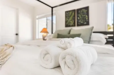 a pile of towels sitting on top of a bed at Charming LA Gem by SOFI, Games & Close to it ALL in Los Angeles