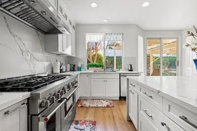 a kitchen with white cabinets and a stove at Luxury Hilltop Home Spacious Private Backyard in Rowland Heights