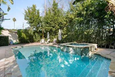 a swimming pool in a yard with chairs and trees at New Listing Burbank Retreat by Colby & Conrad in Burbank