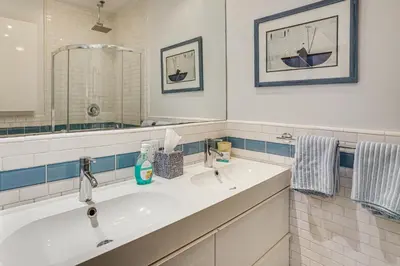 a white bathroom with a sink and a mirror at Beachfront Living in Long Beach 2,500 Sq Ft Condo in Long Beach